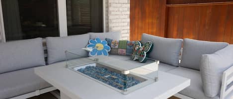 A modern outdoor seating area with a white table and blue decorative elements.