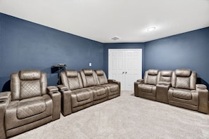A room with two leather recliners, a white door, and a ceiling light. - *NEW* 6BR, 4 Kings, MovieRoom, BilliardS, MiniGolf (Katy)