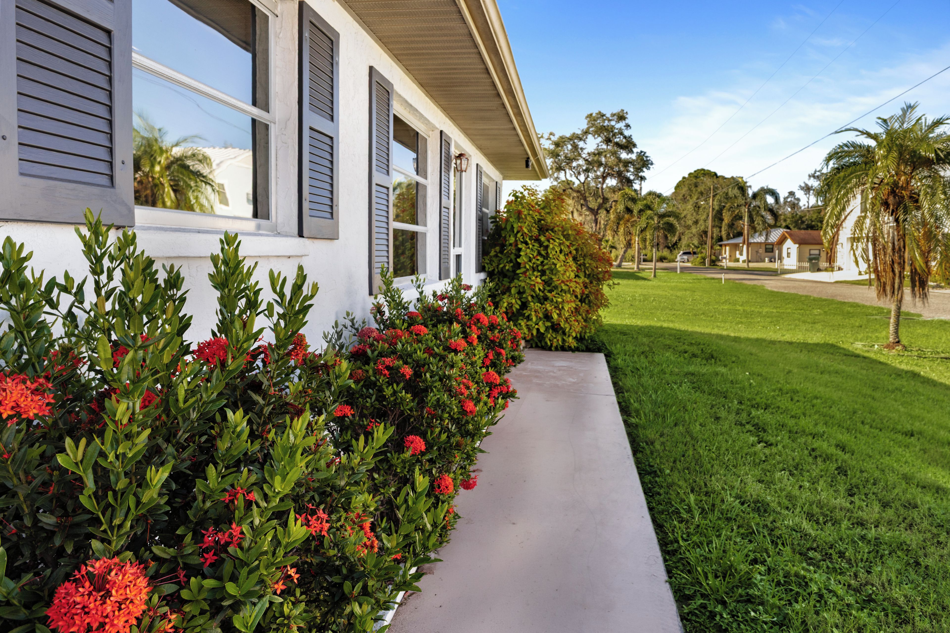 A residential house with a well-maintained lawn and a pathway leading to the entrance.
