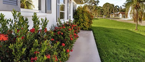 A residential house with a well-maintained lawn and a pathway leading to the entrance.