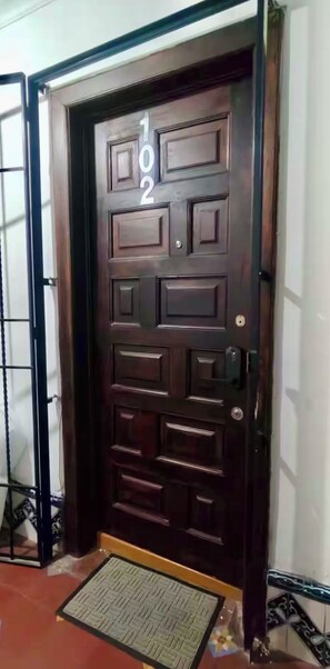 A dark wooden door with the number 102, a metal gate to the left, and a doormat in front. - Apartment 5 minutes from Av. Reforma and the Monument to the Revolution! (Ciudad de México)
