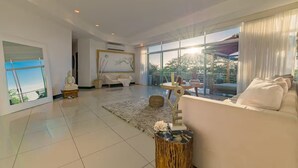 Un salón amplio con un ventanal grande, un sofá blanco y una mesa de centro de madera.