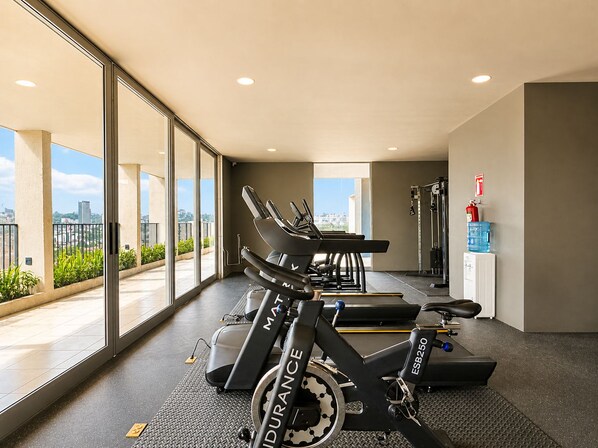 A gym with treadmills, a water dispenser, and a fire extinguisher.