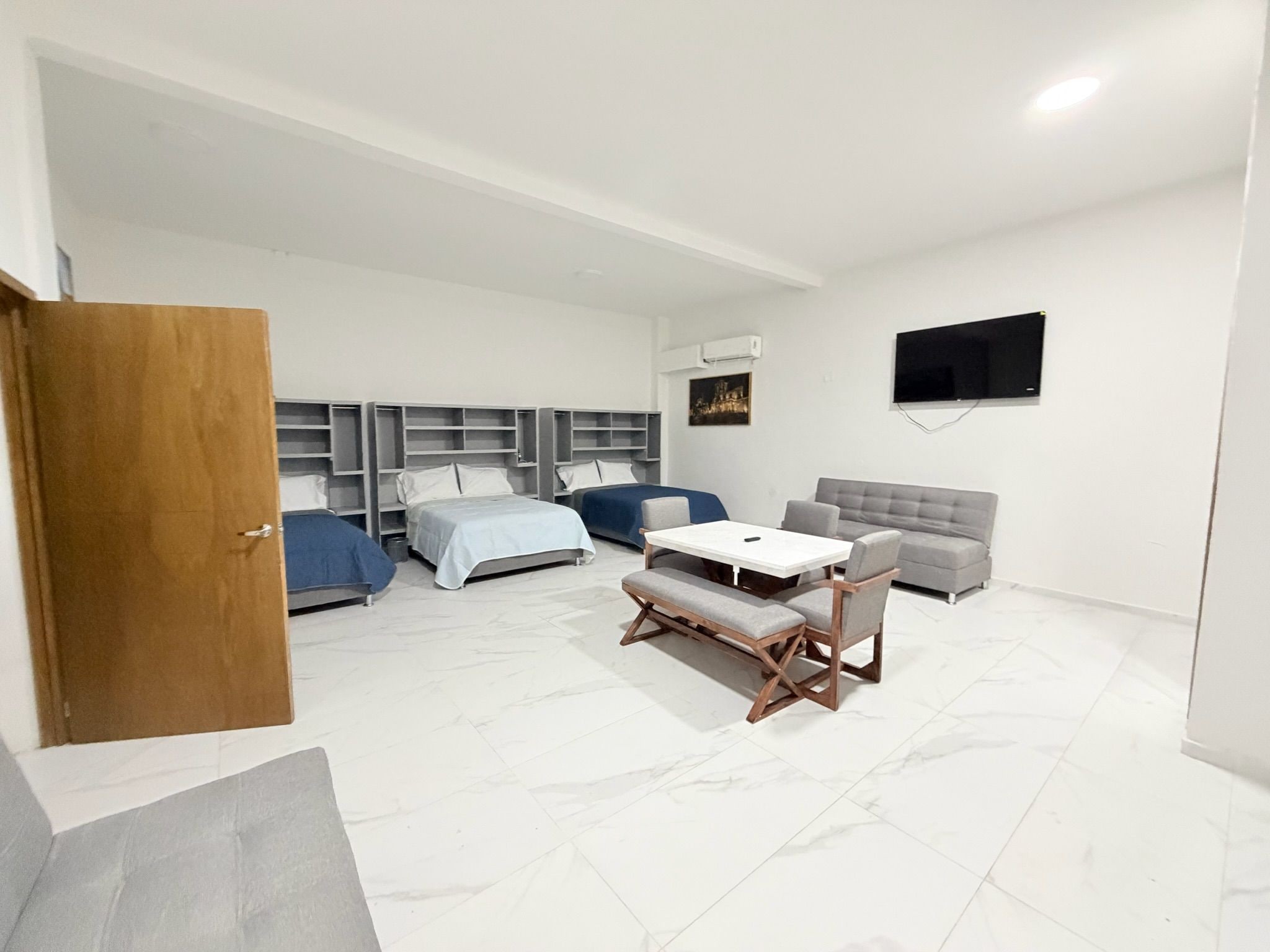 Una habitación de hotel moderna con una cama, un sofá, una mesa y un televisor.