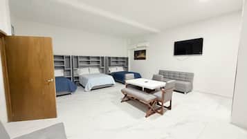 Una habitación de hotel moderna con una cama, un sofá, una mesa y un televisor.
