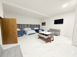 Una habitación de hotel moderna con una cama, un sofá, una mesa y un televisor.