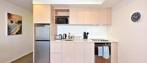 A compact kitchen with a microwave, toaster, sink, and oven.