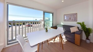 En moderne stue med balkon, spisebord og sofa.