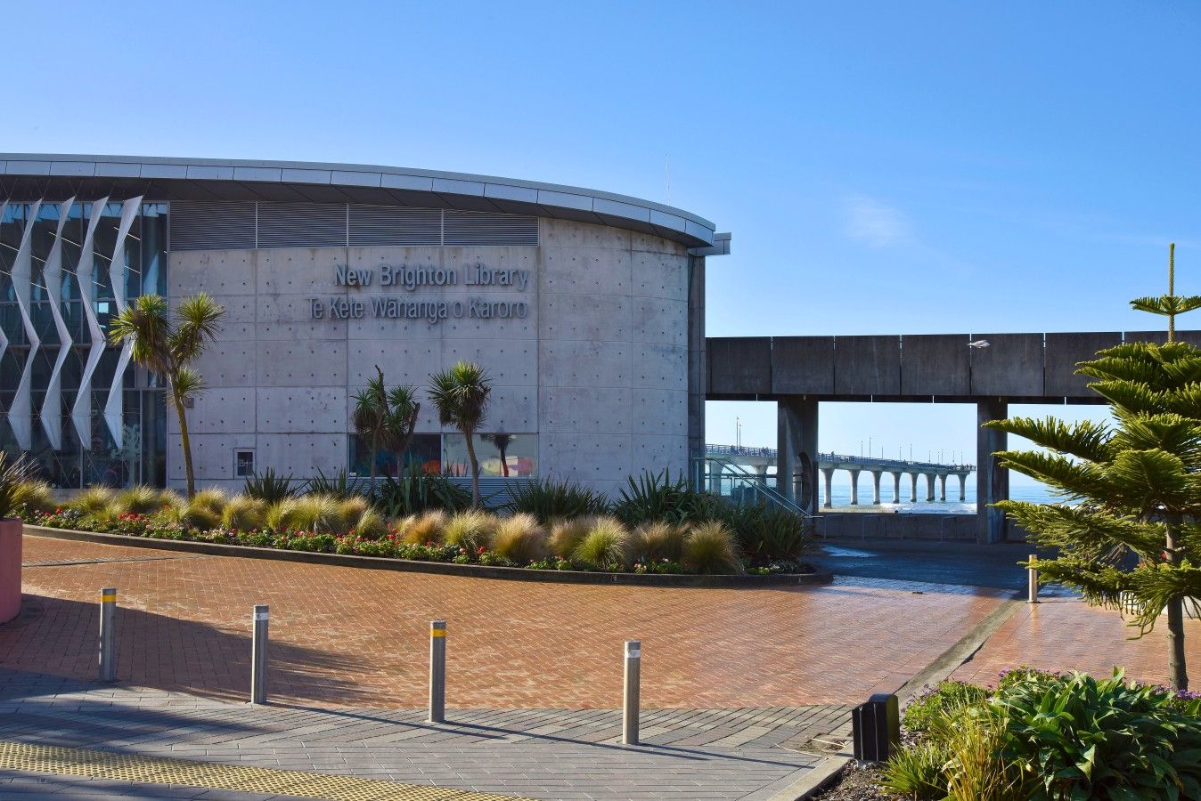 A modern building with the text 'New Brighton Library' and 'Le Kete Wananga o Karoro' on its facade.