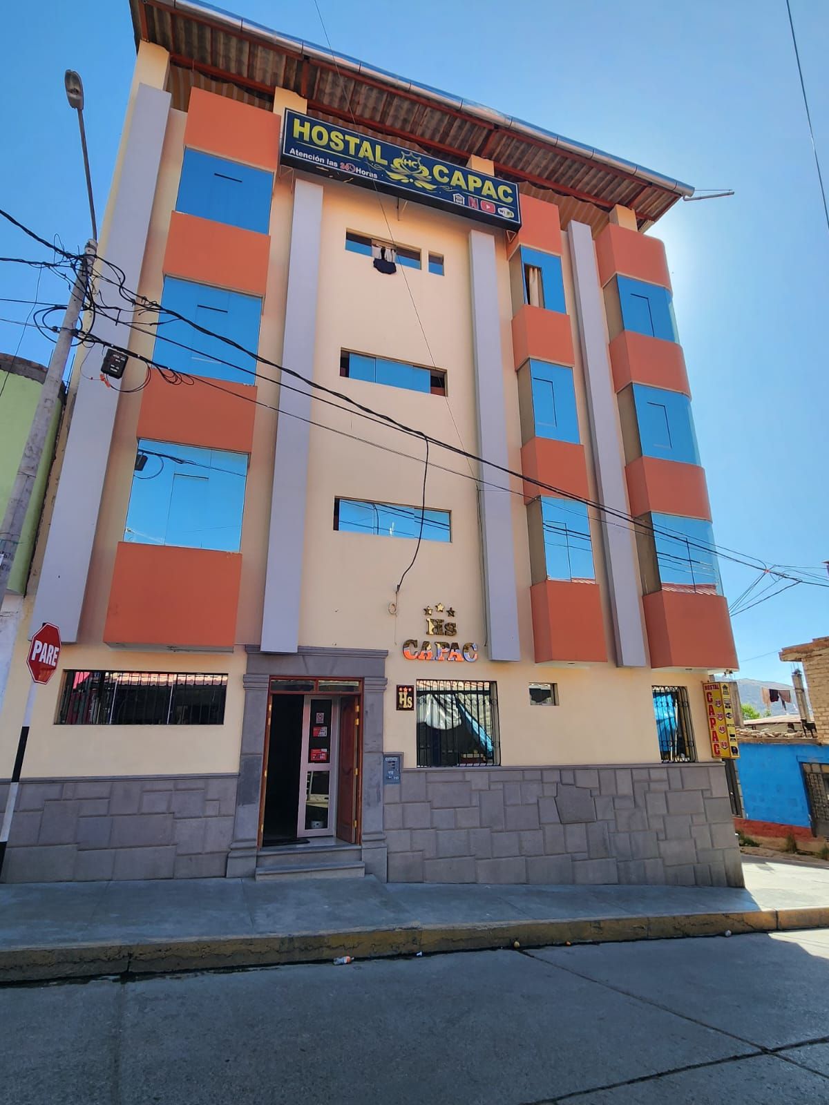 A multi-story building with a sign reading 'HOSTAL CAPAC.'