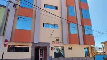 Un edificio de varios pisos con un letrero que dice 'HOSTAL CAPAC'.