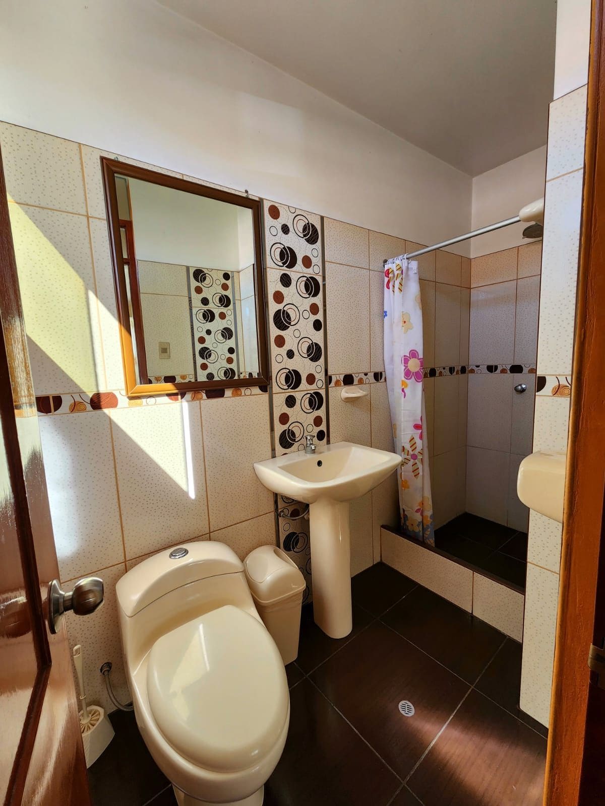 Un baño con inodoro, lavabo y zona de ducha.
