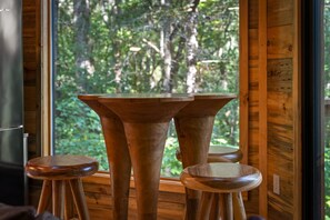 A wooden interior with a table and two stools.