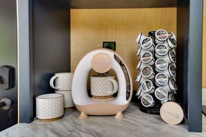 A coffee machine with a beige and white design, a stack of Peet's coffee capsules, and two mugs with a hexagonal pattern. - Juniata River Escape (McVeytown)