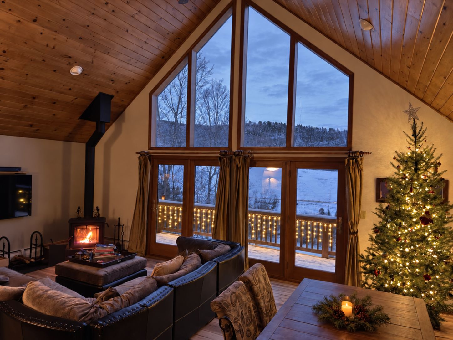 A cozy room with a fireplace, seating area, and a Christmas tree.