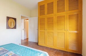 Ein Schlafzimmer mit Bett, Kleiderschrank und einer Badezimmertür.