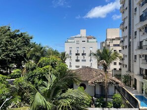 Ein Mehrfamilienhaus, umgeben von üppiger Vegetation und Palmen.