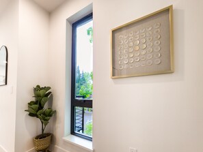 A room with a window, a framed artwork on the wall, and a potted plant. - Modern 3-bedroom Capitol Hill Home with Full Kitchen (Seattle)