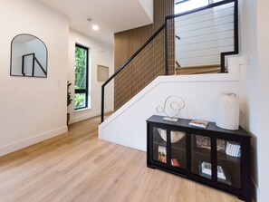 A modern interior with a staircase, a console table with decorative items, and a framed picture on the wall. - Modern 3-bedroom Capitol Hill Home with Full Kitchen (Seattle)