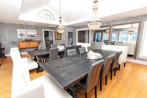 A spacious dining area with a large table, multiple chairs, and elegant chandeliers. - OCEANFRONT, Ocean & Sound Views, Priv Pool, SAUNA-PM3, Palmers View (Duck)