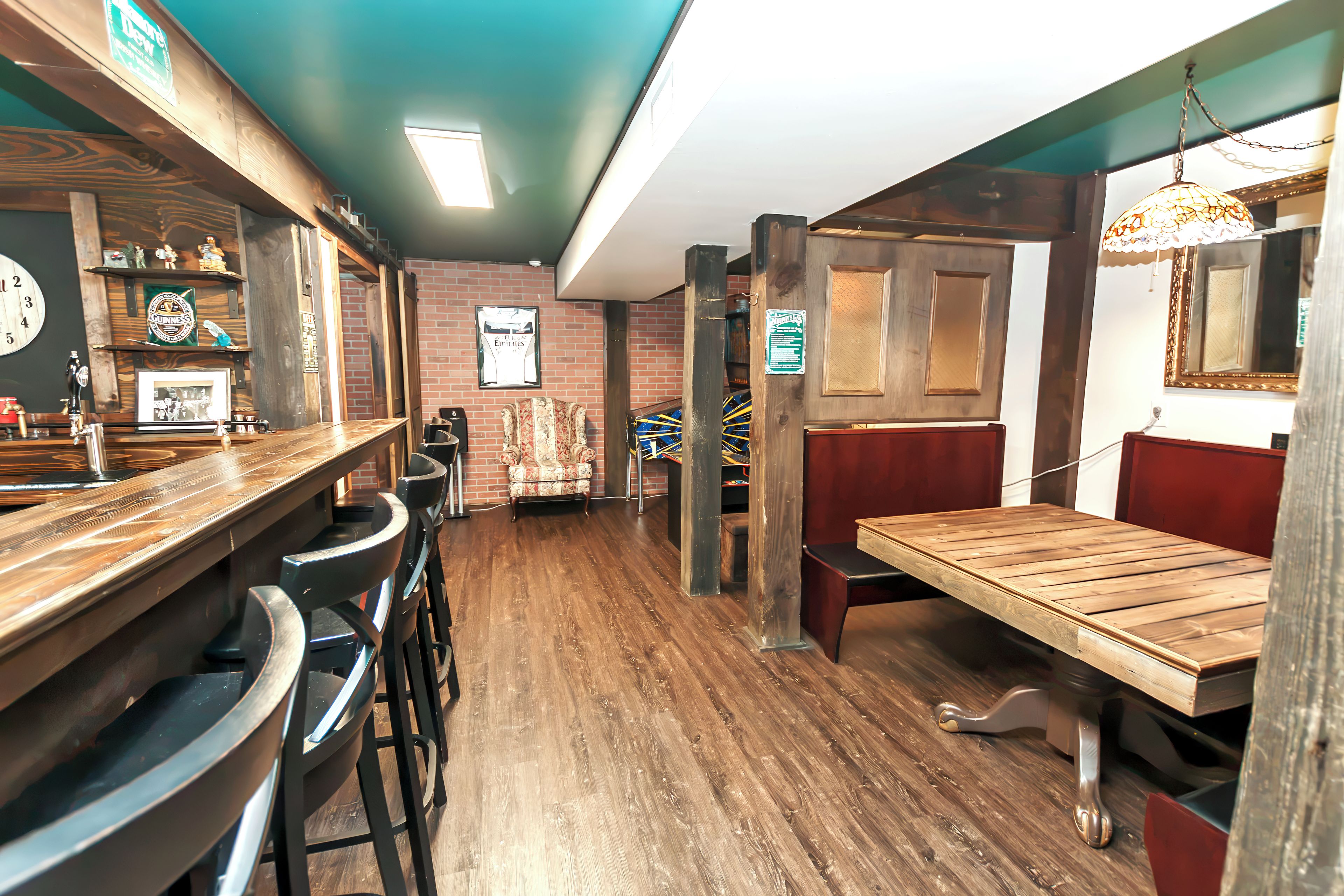 A bar area with stools, a wooden bar counter, and a seating area with a table and chairs.