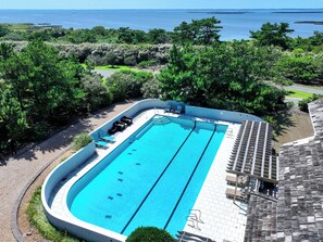 A rectangular swimming pool with a surrounding deck, lounge chairs, and a view of the sea. - OCEANFRONT, Ocean & Sound Views, Priv Pool, SAUNA-PM3, Palmers View (Duck)