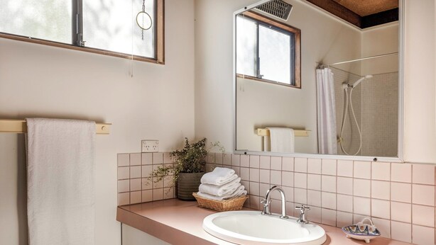A bathroom with a sink, mirror, and shower. - New: Quitch Cottage - steps from the beach (Quindalup)