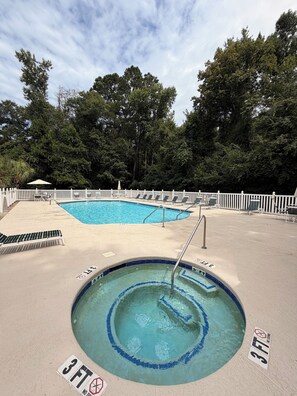 A swimming pool with a 3 FT depth marker, surrounded by a white fence, with trees in the background. - Coastal 2B condo minutes from the beach & attractions with pool and golf access! (Longs)