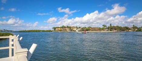 Vista al agua con un muelle, agua tranquila y edificios al otro lado.