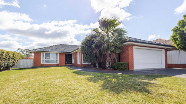A residential house with a garage, a lawn, and a palm tree. - The Apex, Pet-Friendly Dubbo Home (Dubbo)