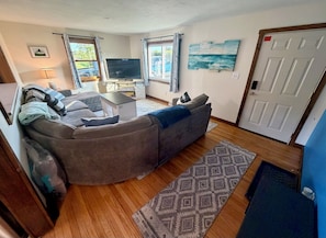 A living room with a sofa, a TV, and a rug. - Get the break you deserve, at the River Respite. (Memphis)