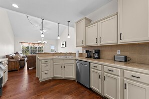 A modern kitchen with white cabinetry, a dishwasher, and a coffee maker. - Stay in the Heart of Branson • Gated 3BR Townhome • Pool • Near Shows, Shopping & Golf (Branson)