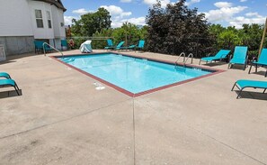 A rectangular pool with a red border, surrounded by blue lounge chairs and a concrete deck. - Stay in the Heart of Branson • Gated 3BR Townhome • Pool • Near Shows, Shopping & Golf (Branson)