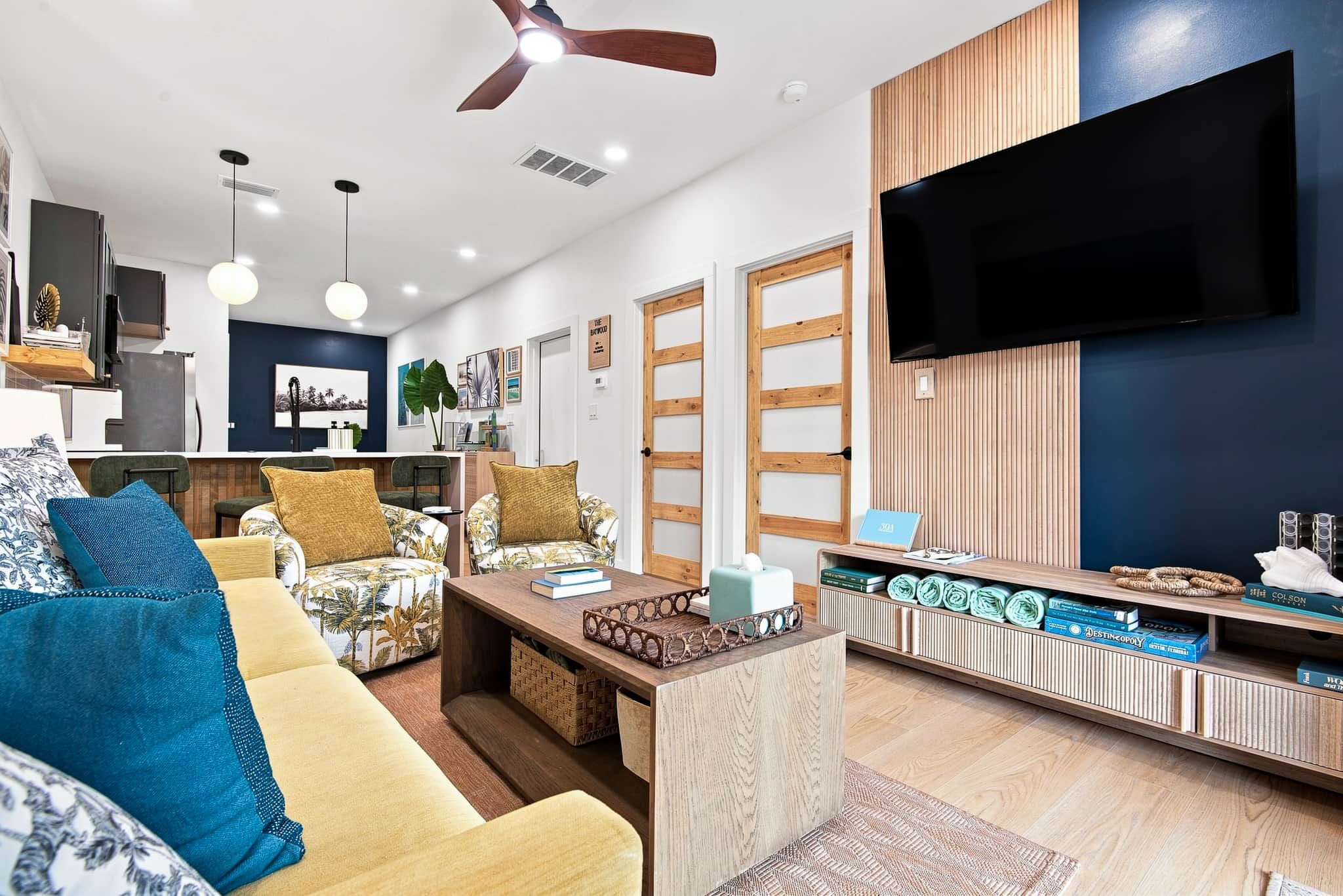 A modern living room with a sofa, coffee table, and a TV mounted on the wall.
