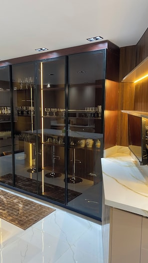 A modern kitchen with a glass-fronted cabinet, stainless steel appliances, and a marble countertop. - Near the pyramids and the new Grand Egyptian Museum! (Pyramids garden)