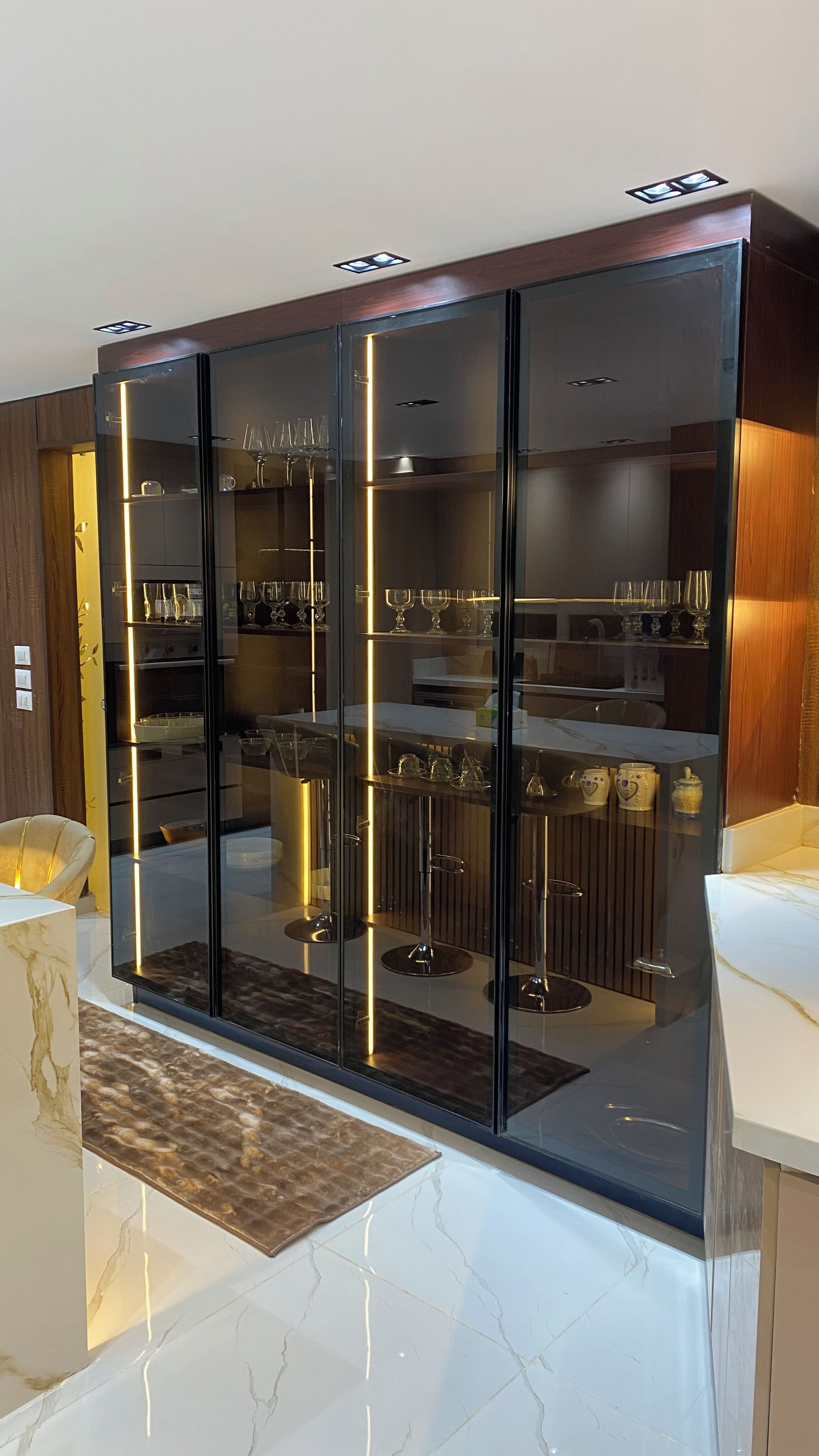 A modern kitchen with a built-in wine rack and a marble countertop.