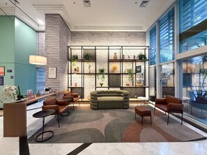 A modern lobby with a seating area, a reception desk, and a large window. - Vrbo Property (São Paulo)