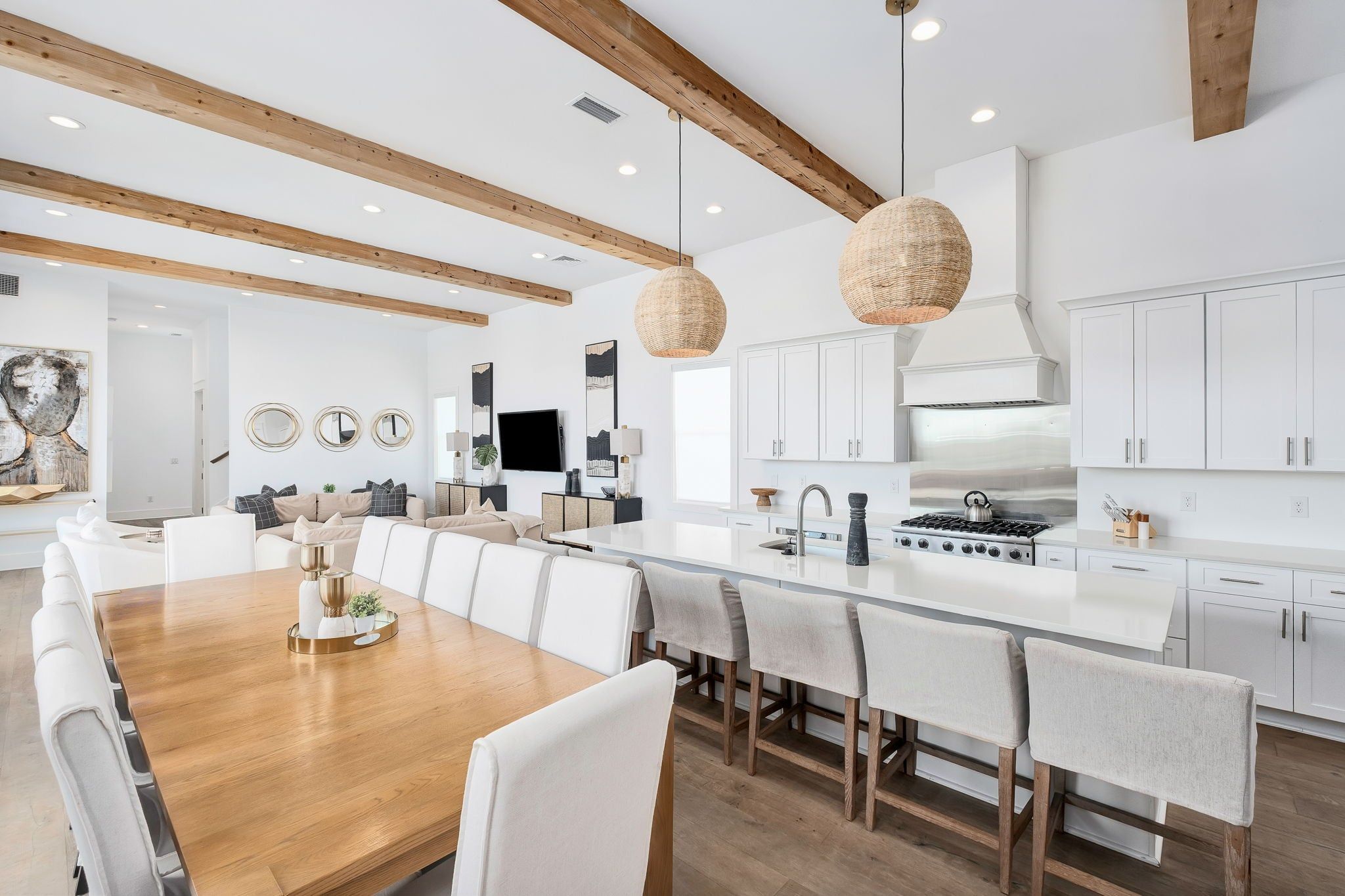 A modern kitchen with white cabinetry, a central island, and pendant lighting.