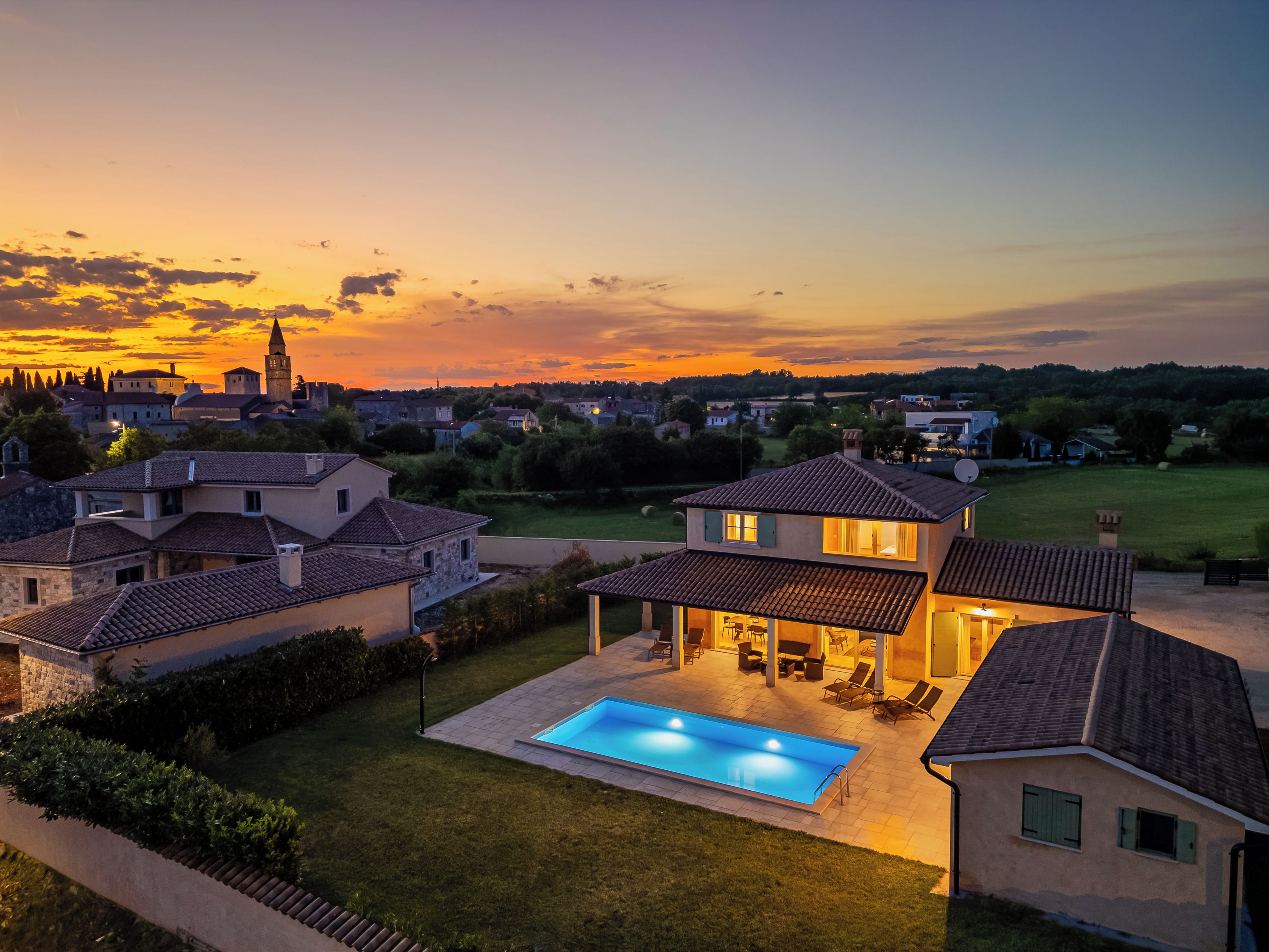 Un quartier résidentiel avec des maisons, une piscine et une tour qui se dresse au loin.