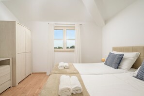 A hotel room with a bed, a bedside table, a wardrobe, and a window with curtains. - Villa Flori (Istria - Svetvinčenat) (Svetvinčenat)