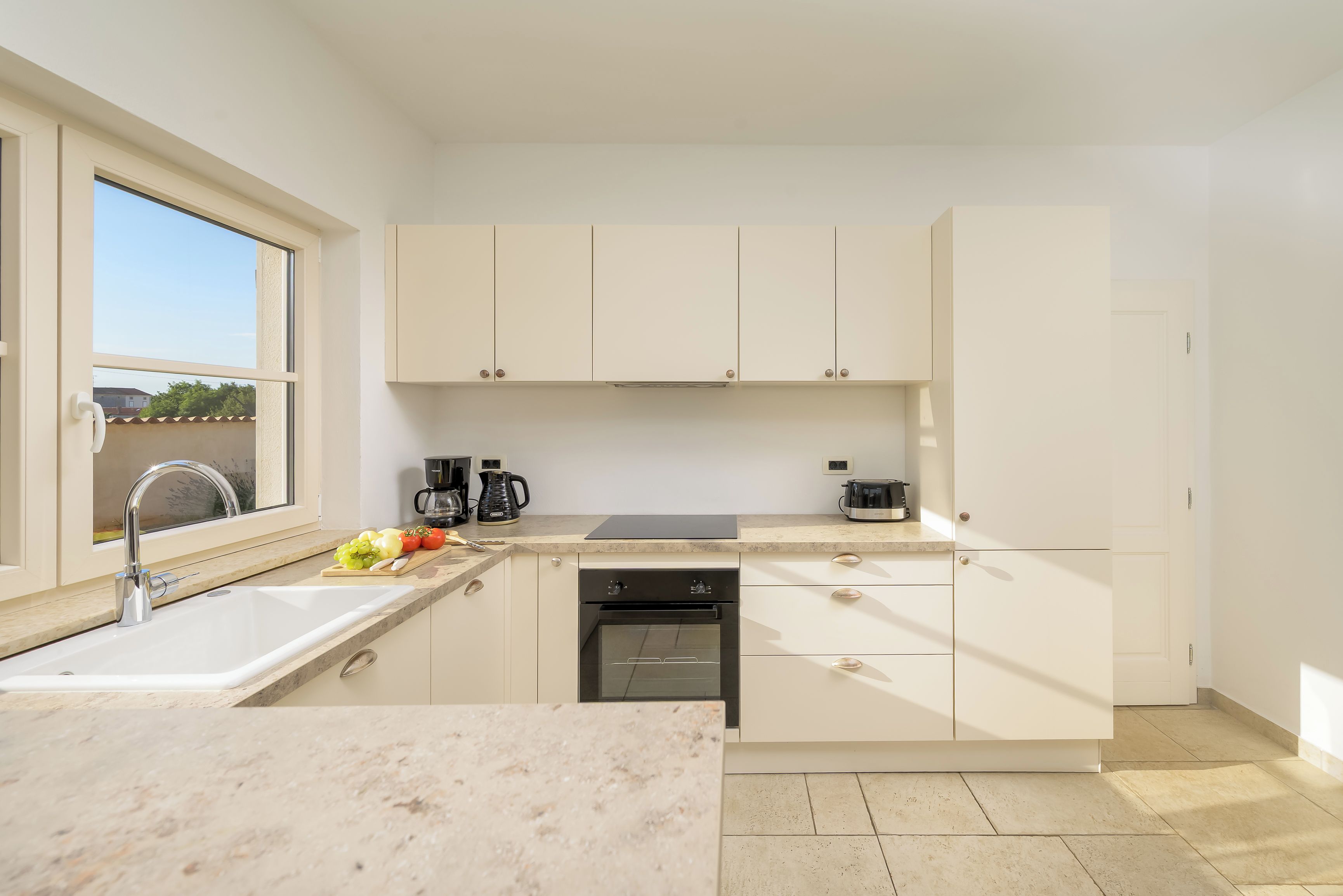 Een moderne keuken met een spoelbak, aanrecht en apparatuur.