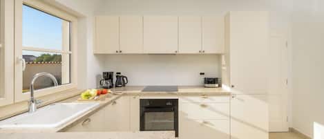 Una cocina moderna con un lavamanos, encimera y electrodomésticos.