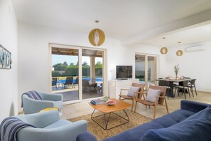 A modern living room with a sofa, armchairs, a coffee table, and a dining area with chairs and a table. - Villa Flori (Istria - Svetvinčenat) (Svetvinčenat)