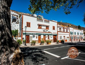 A street view with buildings, including a restaurant named 'Cueva del Molino'. - Cave Retreat for 3 Guests (Artenara)