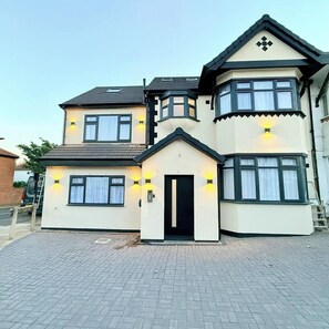 A two-story house with a bay window and a small porch. - Chic London Escape | 5 Min Walk to Tube (Greater London)