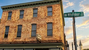 A brick building with a green street sign for Whitaker St.