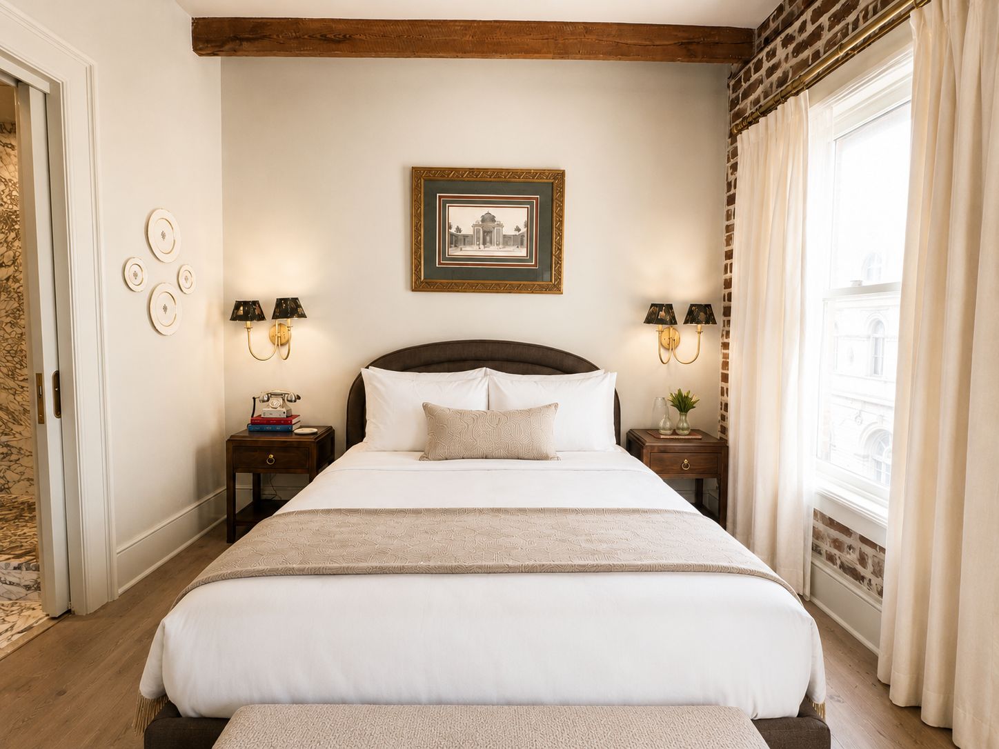 Una habitación de hotel con una cama grande, dos mesitas de noche con lámparas, un cuadro en la pared y una ventana con cortinas.
