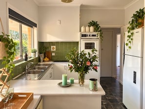 A kitchen with a central island, a built-in oven, and a refrigerator. - Nagambie Country Stay | Waters Edge (Strathbogie)