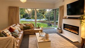 Una sala de estar con sofá, mesa de centro, chimenea y televisor.