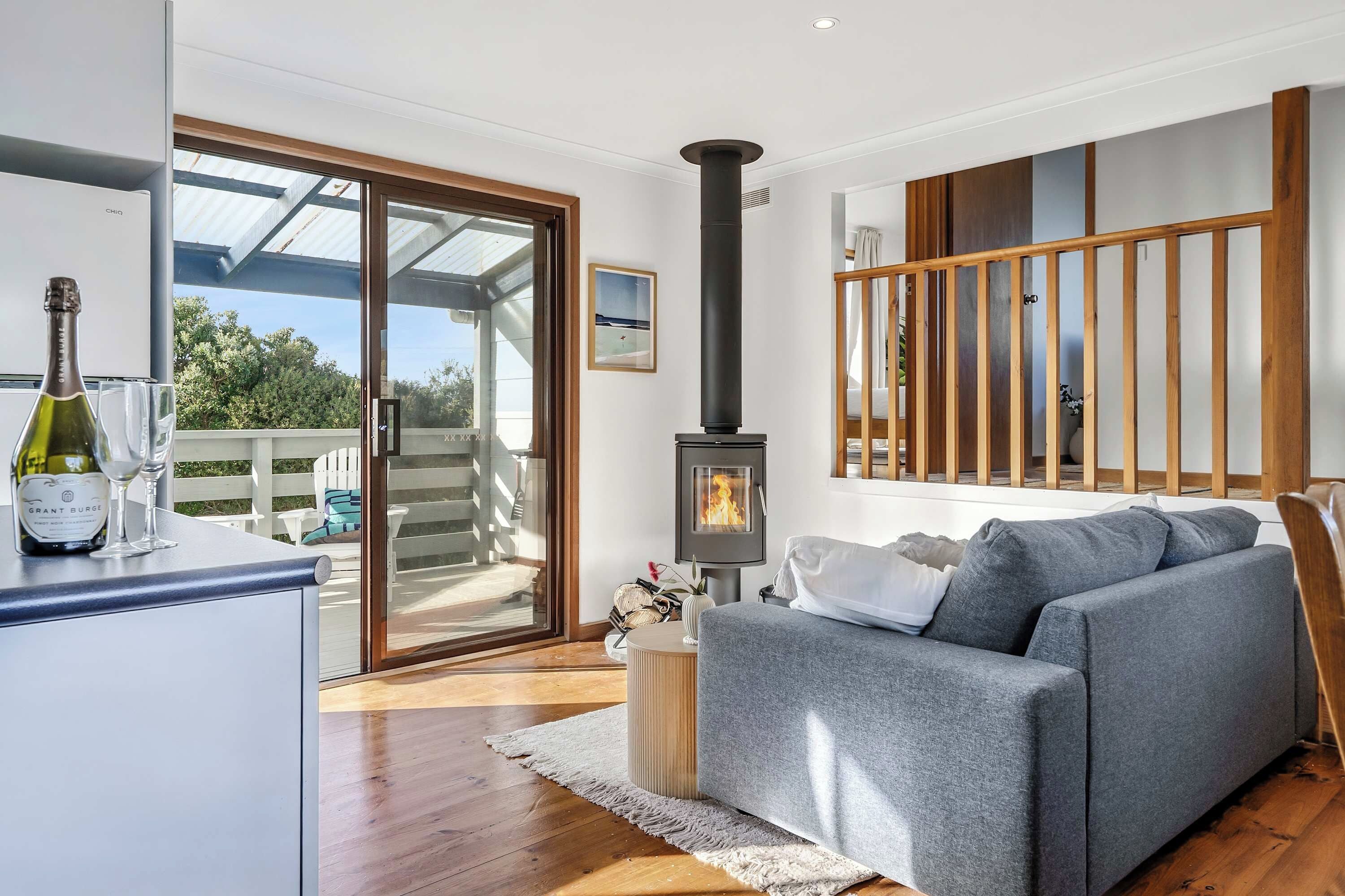 A modern living room with a sofa, a fireplace, and a dining area with a table and chairs.